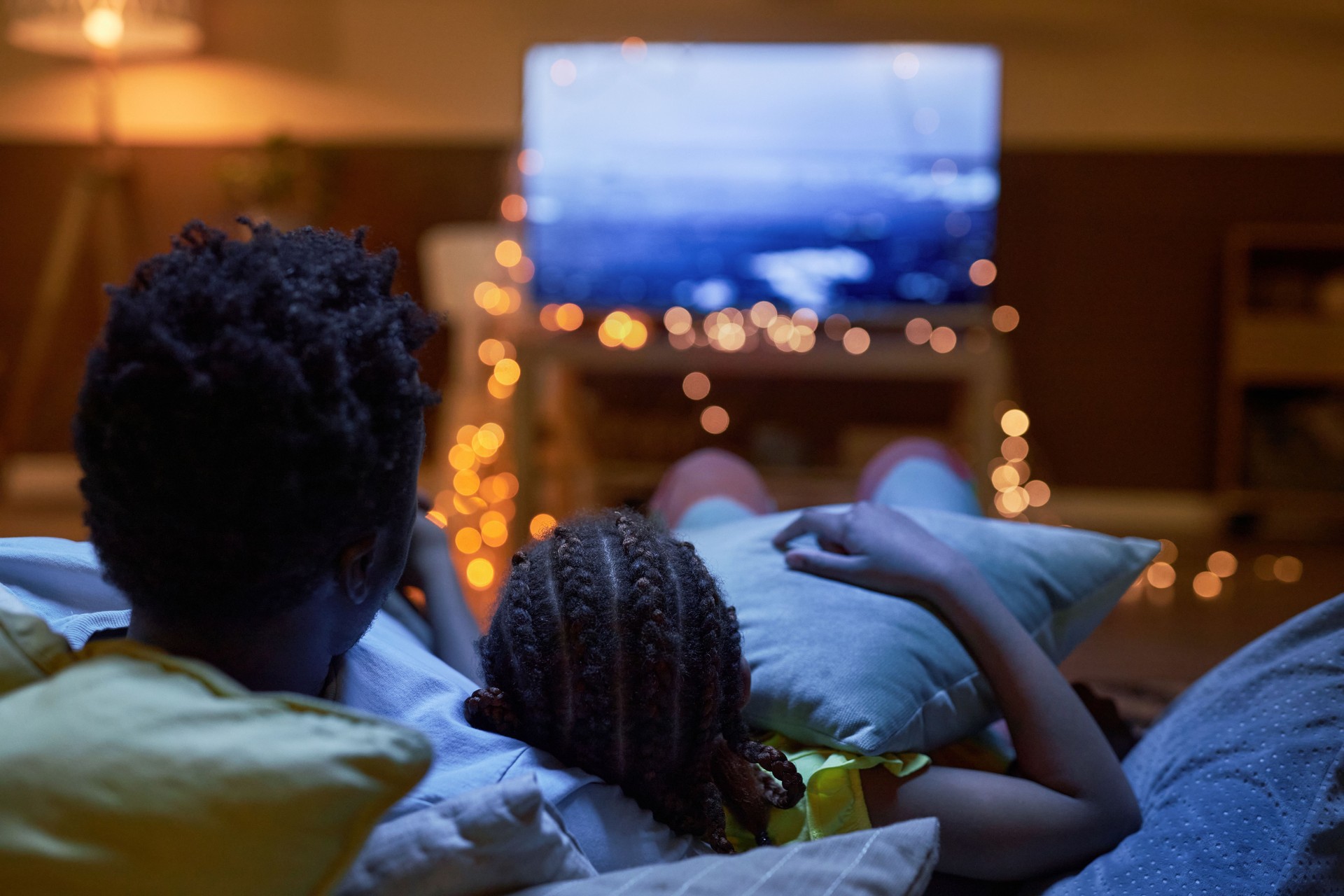 Famille regardant la télévision ensemble dans l’obscurité